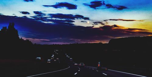 Cars on road at sunset