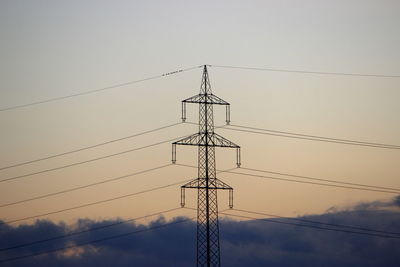 Low angle view of electricity pylon against clear sky