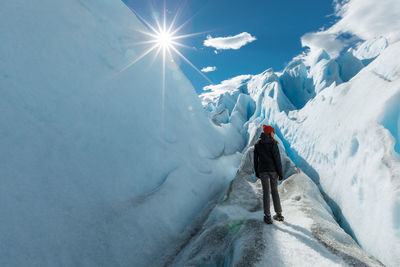 Rear view of person on snowcapped mountains during winter