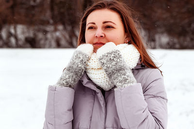 Portrait of young woman standing on snow