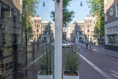 People walking on street amidst buildings in city