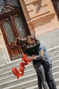 Couple embracing while standing outdoors