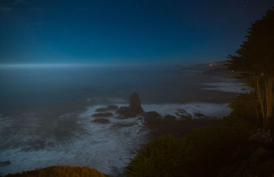 Scenic view of beach against sky at night