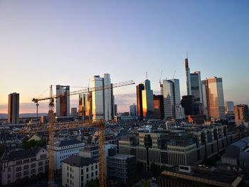 Modern buildings in city against clear sky during sunset