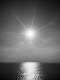 Scenic view of sea against bright sun