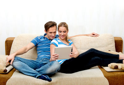 Friends sitting on sofa at home
