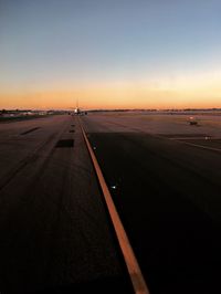 View of airport runway against sky during sunset