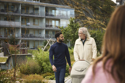 Men with baby stroller walking in residential area