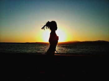 Silhouette of woman standing on beach