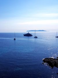 Sailboats in sea against sky