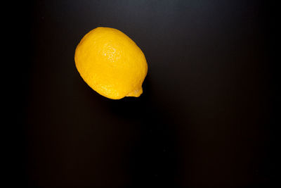 Close-up of orange apple against black background