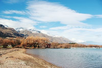 Scenic view of lake by mountains against sky