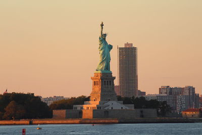 Statue in city against clear sky