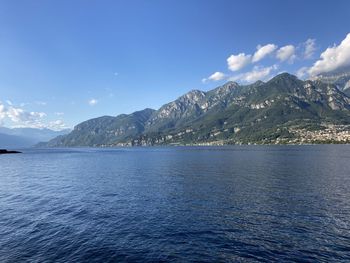 Scenic view of sea and mountains against blue sky