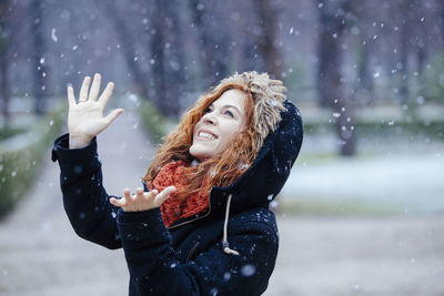 Young woman with arms raised in snow
