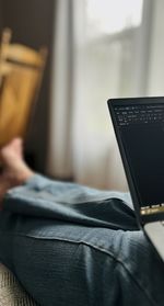 Midsection of woman using laptop at home