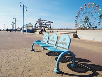 Deck chairs on beach against blue sky