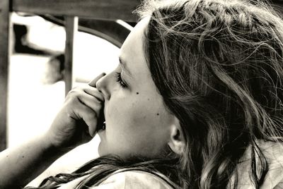 Close-up of thoughtful teenage girl resting by window