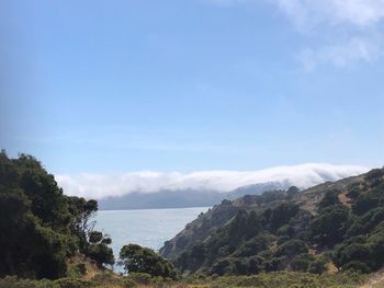 Scenic view of sea and mountains against sky