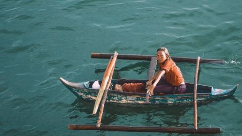 Man sitting in boat against sea