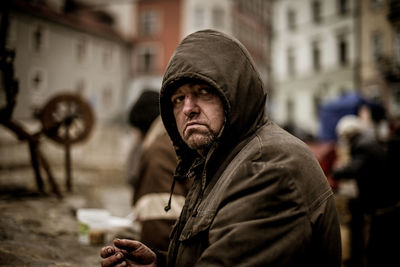 Portrait of man standing on street in city