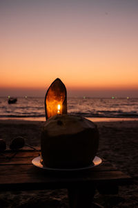 Lifeguard hut on beach against sky during sunset