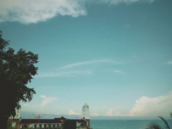 Scenic view of sea by buildings against sky