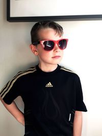 Portrait of boy wearing sunglasses while standing against wall