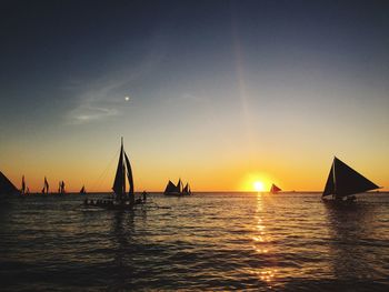 Sailboat in sea at sunset
