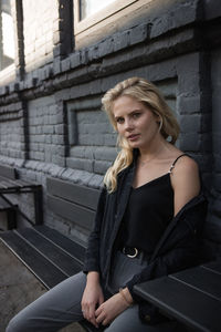 Portrait of young woman sitting outdoors