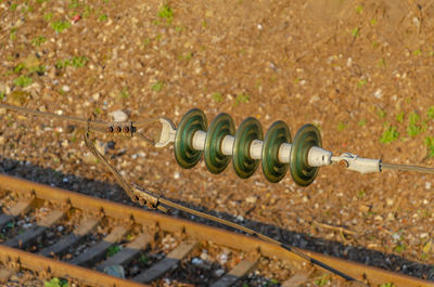 Insulator on high-voltage power line. blurred railway track background.