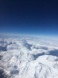 Scenic view of snowcapped mountains against blue sky