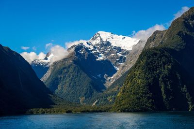 Scenic view of snowcapped mountains against blue sky