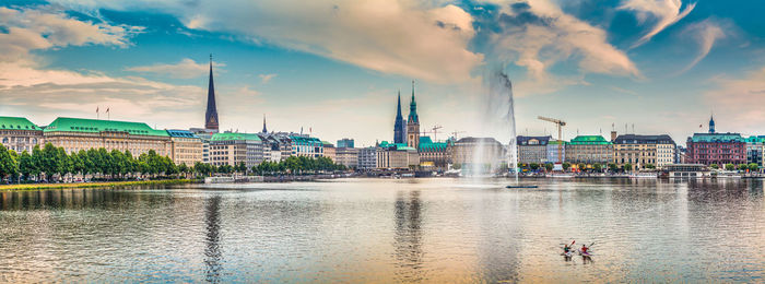 Panoramic view of buildings against cloudy sky