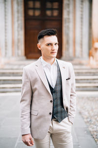 Young man standing against building in city