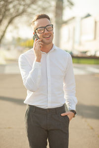 Full length of a young man using phone on street