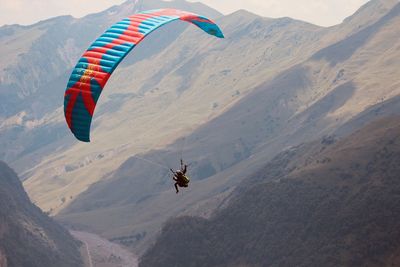 Person paragliding over mountain