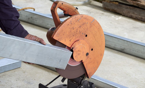 Cropped hand of man using grinder in workshop