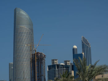 Low angle view of modern buildings against clear blue sky