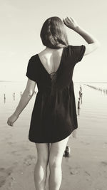 Rear view of woman standing on beach
