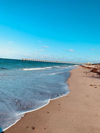 Scenic view of beach against blue sky