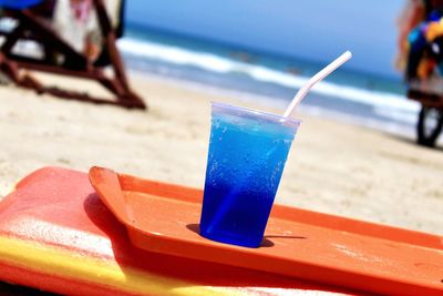 Close-up of drink on beach