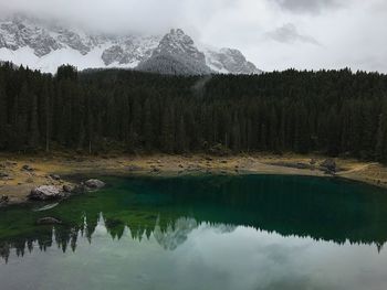 Scenic view of lake by snowcapped mountains against sky