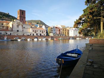Boats moored on canal against buildings in city