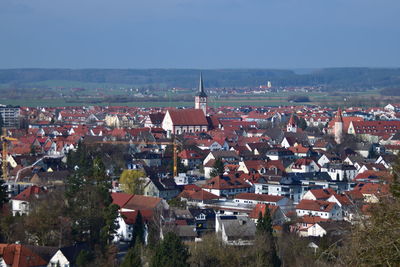 Aerial view of houses in town against sky