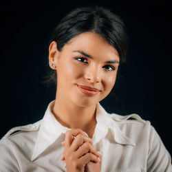 Portrait of a beautiful young woman over black background