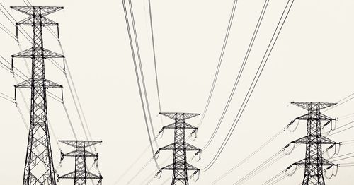 Low angle view of electricity pylon against clear sky