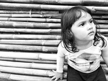 Close-up of girl sitting on bamboos