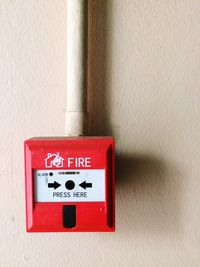 Close-up of fire alarm against wall