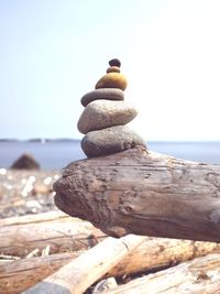 Close-up of stack on wood against sea